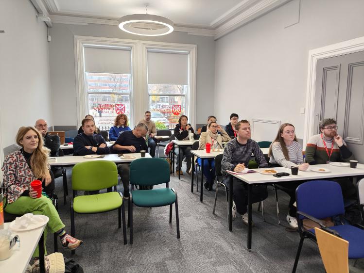 Picture of students and staff listening to a presentation